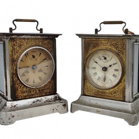 #63062 -  Pair of antique metal carriage clocks featuring decorative dials and top handles.
