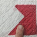 Handmade quilt with red geometric pattern. - 2